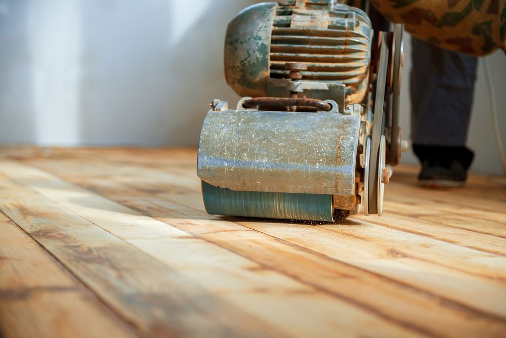 A Person is Sanding a Wooden floor with a Machine — Radburn Carpentry in Tamworth, NSW