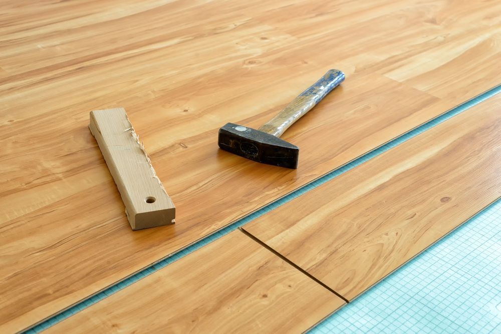 A Hammer and a saw are on a Wooden floor — Radburn Carpentry in Tamworth, NSW