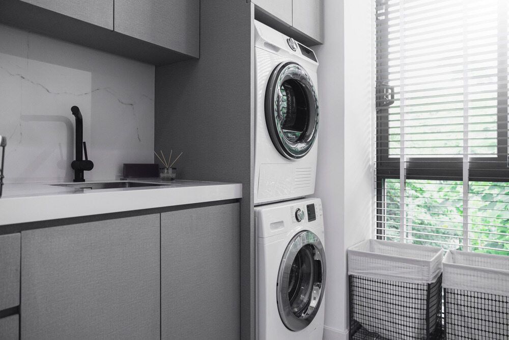 A Laundry Room with A Washer and Dryer Stacked on Top of Each Other — Radburn Carpentry in Tamworth, NSW