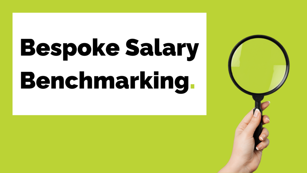 A person is holding a magnifying glass in front of a sign that says bespoke salary benchmarking.