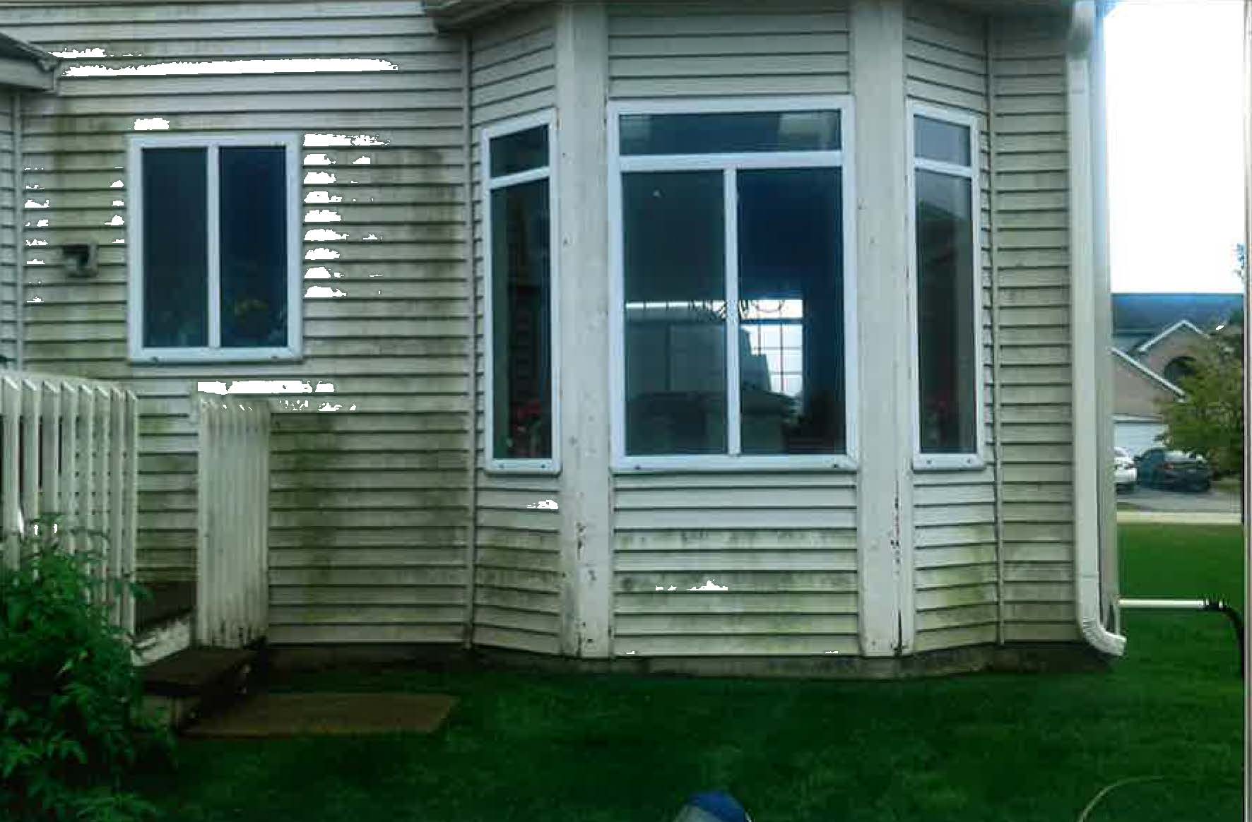 A house with a lot of windows and a lawn in front of it