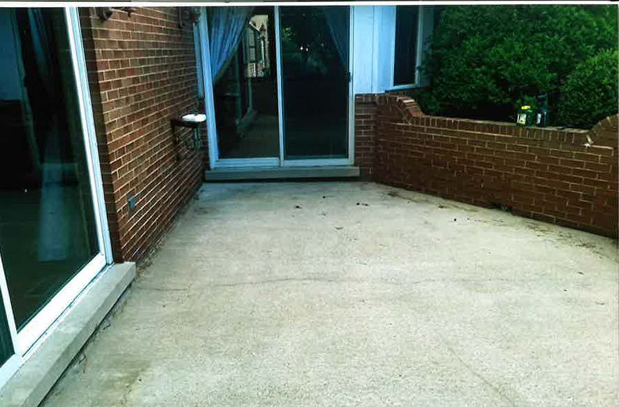 A patio with a brick wall and a sliding glass door