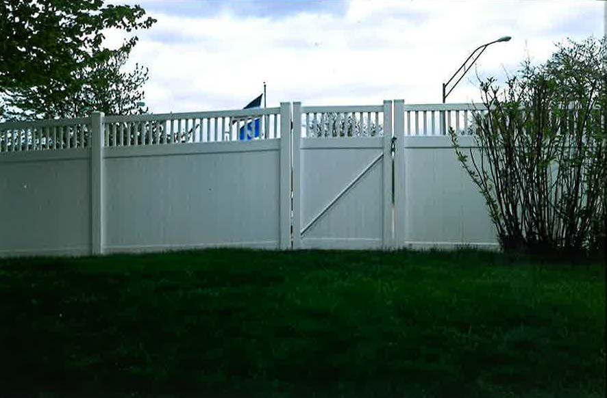A white fence with a gate in front of it