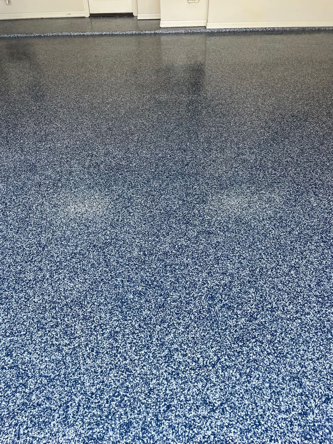 A close up of a blue epoxy floor in a garage.