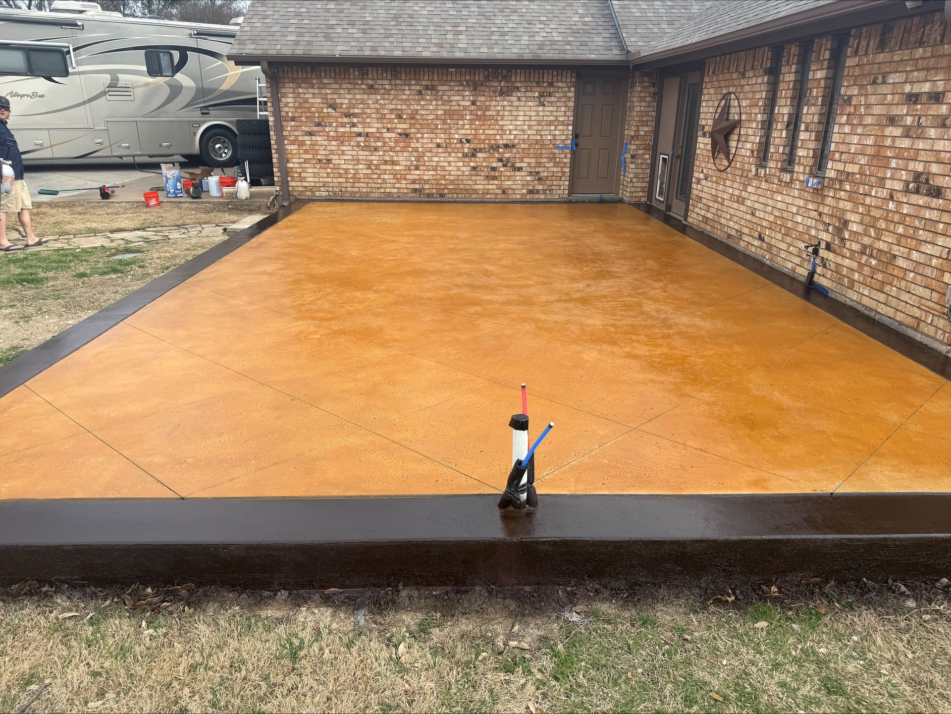 A brick house with a concrete driveway in front of it.