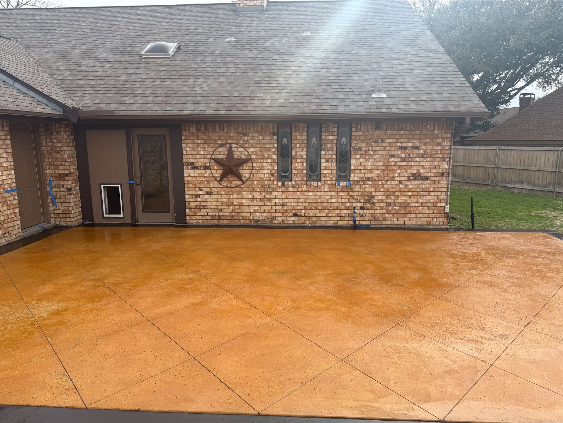 A brick house with a concrete driveway in front of it.