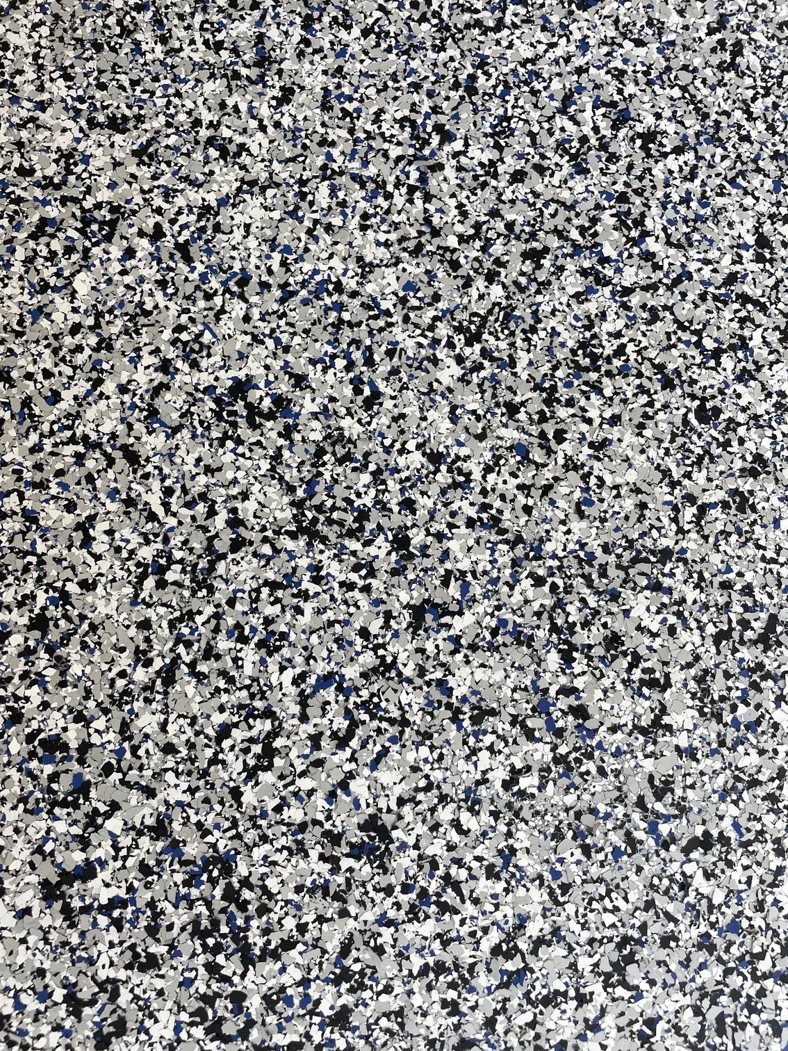 A close up of a gray , white , and blue concrete floor.