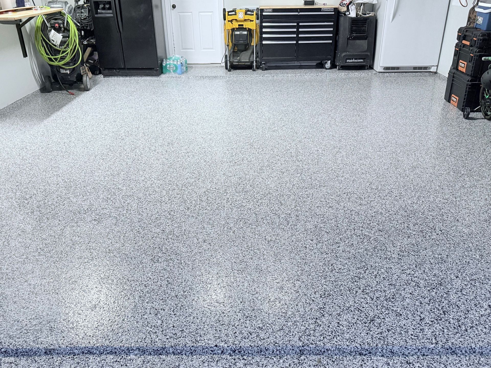 A garage floor with a lot of tools on it.