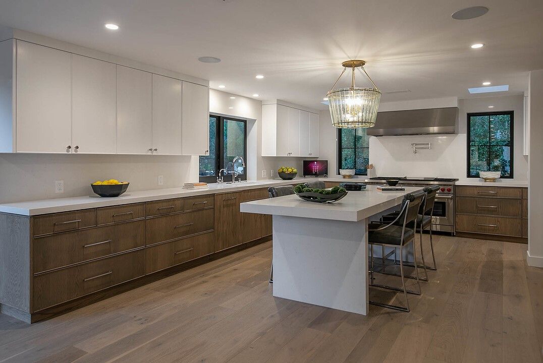A kitchen with white cabinets and a large island
