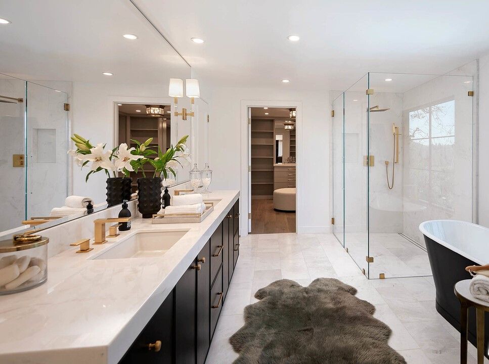 A bathroom with two sinks , a bathtub and a walk in shower.