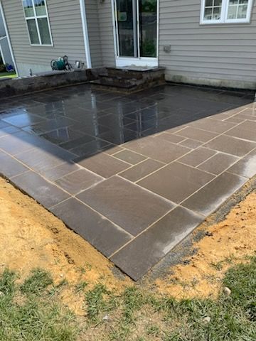 A patio is being built in front of a house.