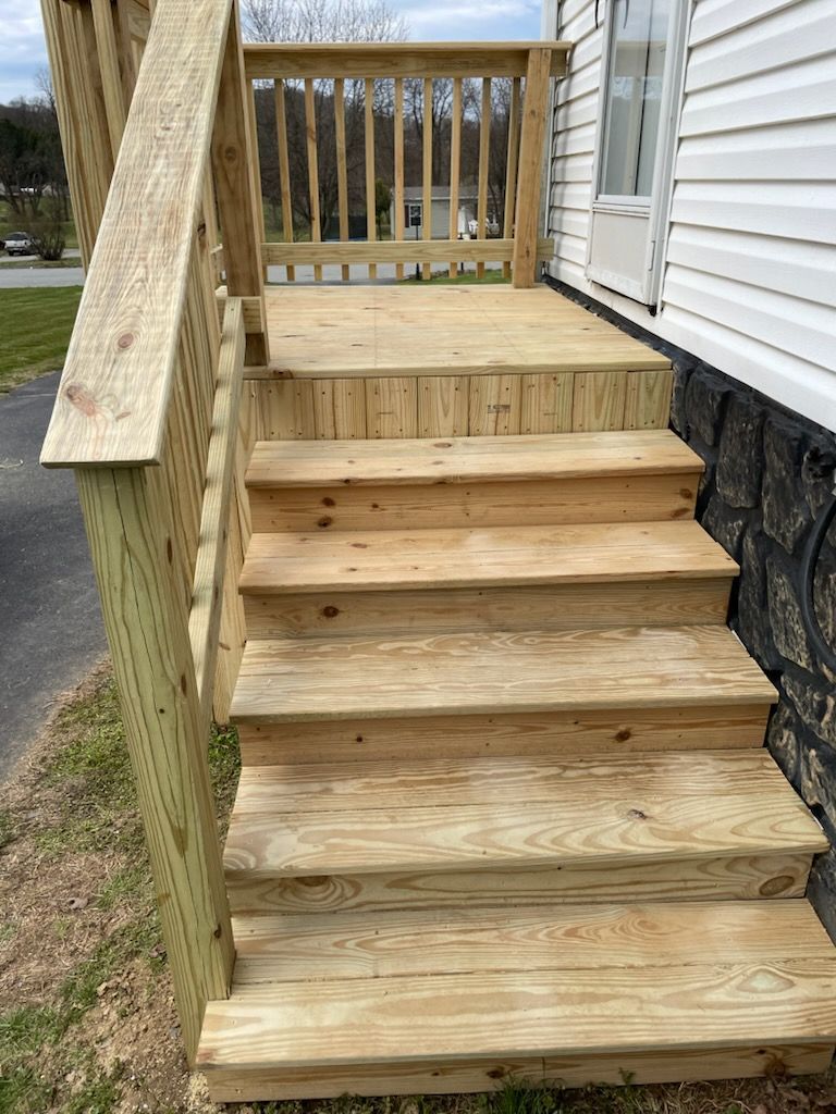 A wooden deck with stairs leading up to a house.