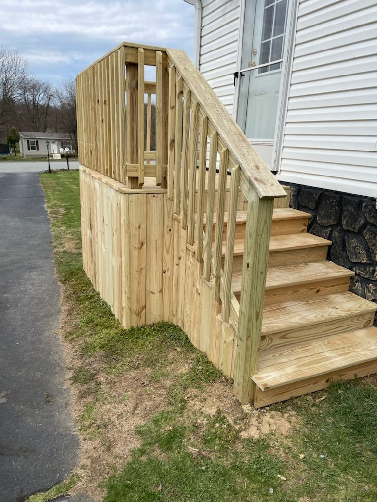 A wooden deck with stairs leading up to a house.