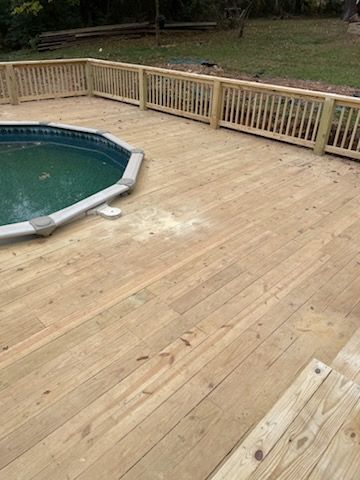 A wooden deck with a swimming pool in the background.