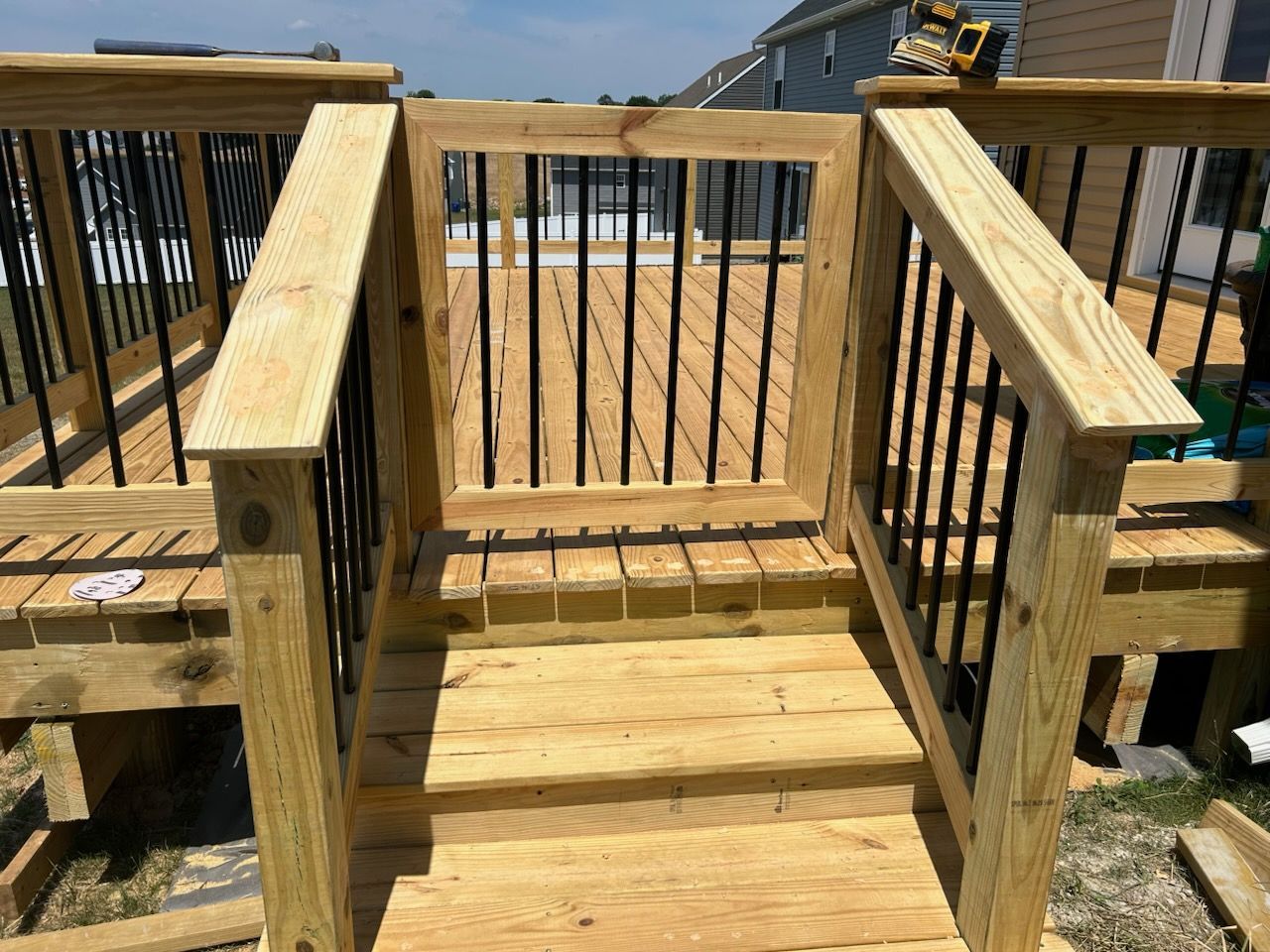 A wooden deck with a gate and stairs leading to it.