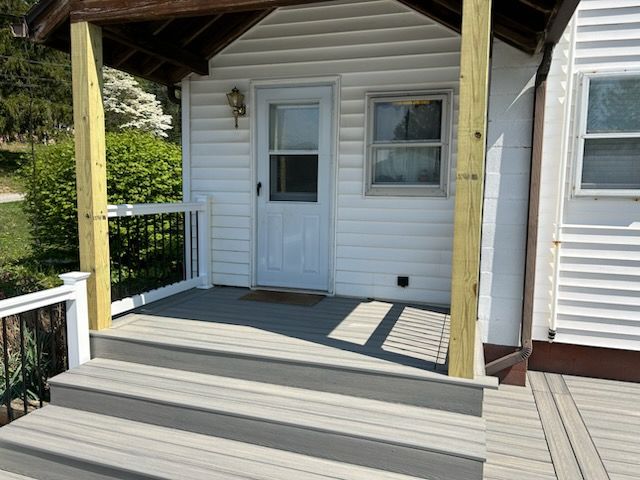 A white house with a porch and stairs leading to it