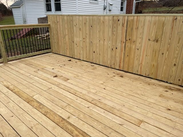 A wooden deck with a wooden fence surrounding it.