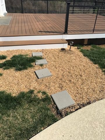 A walkway with stepping stones leading to a deck.