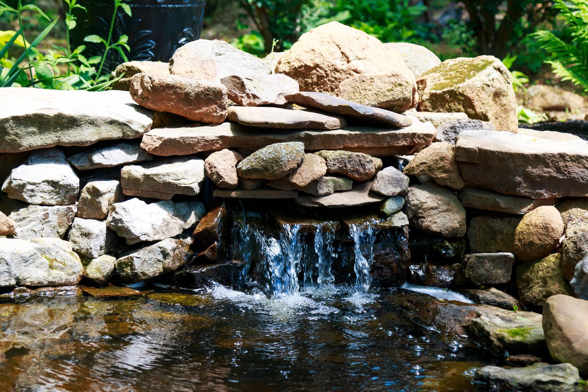 A Small Waterfall is Surrounded by Rocks in a Garden