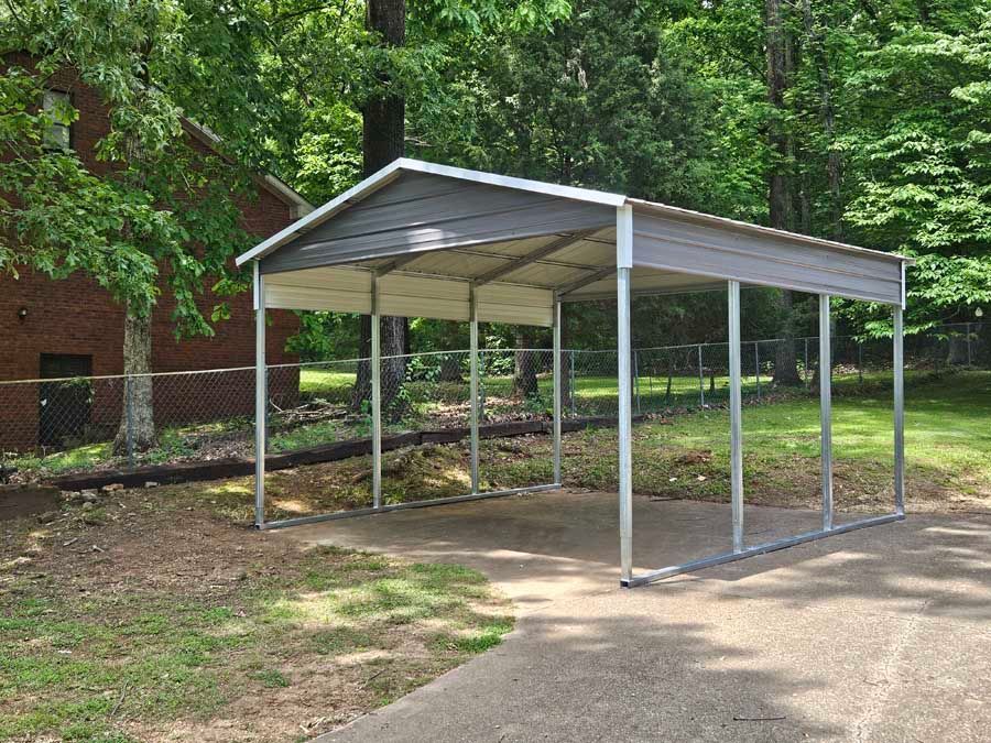 Metal carport in a yard with a concrete driveway.