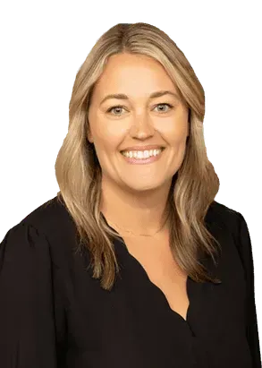A smiling professional posing against a plain white background, wearing a black top.