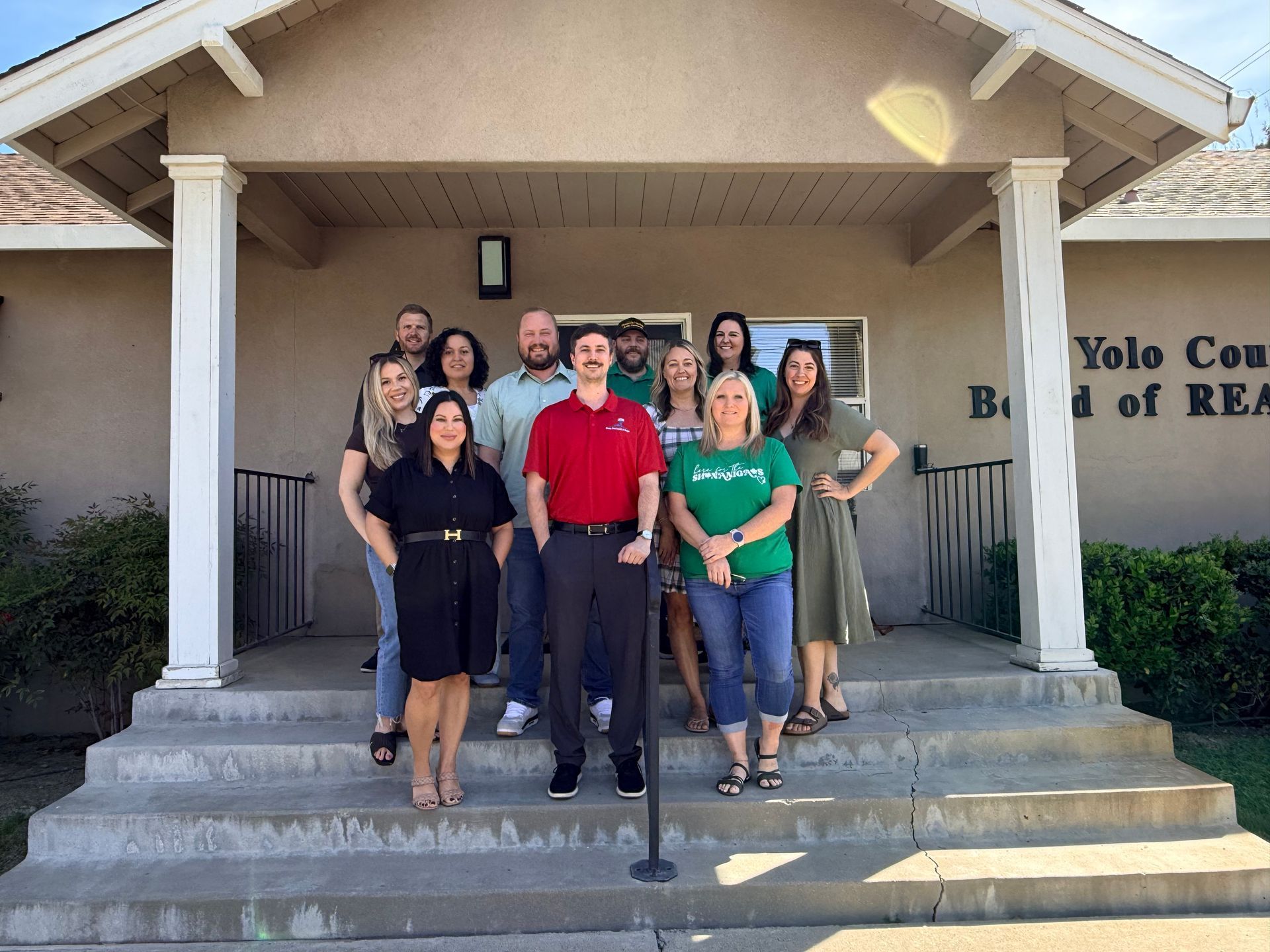 Two people in formal attire shake hands in an office setting.