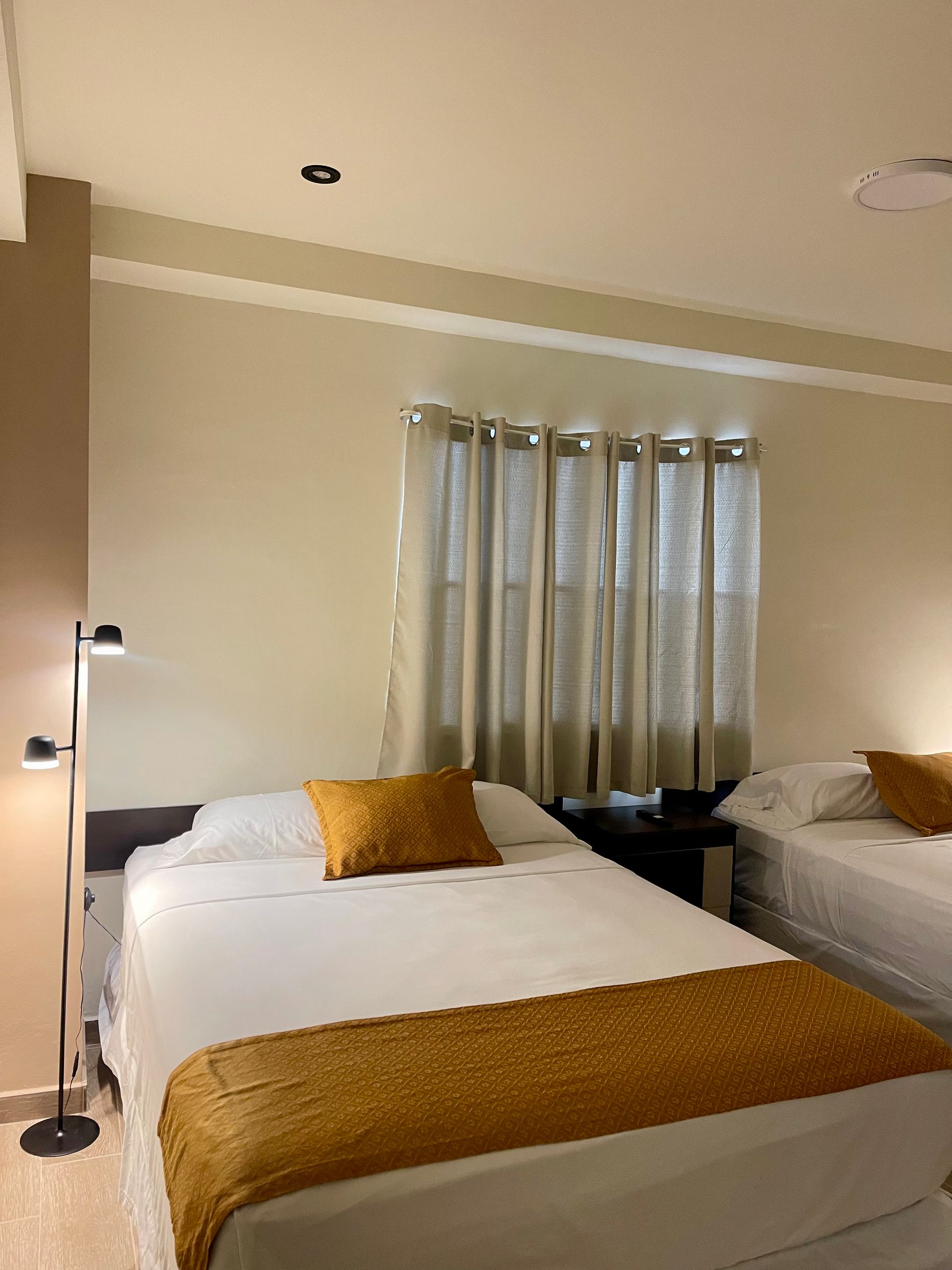 A hotel room with two beds and a lamp