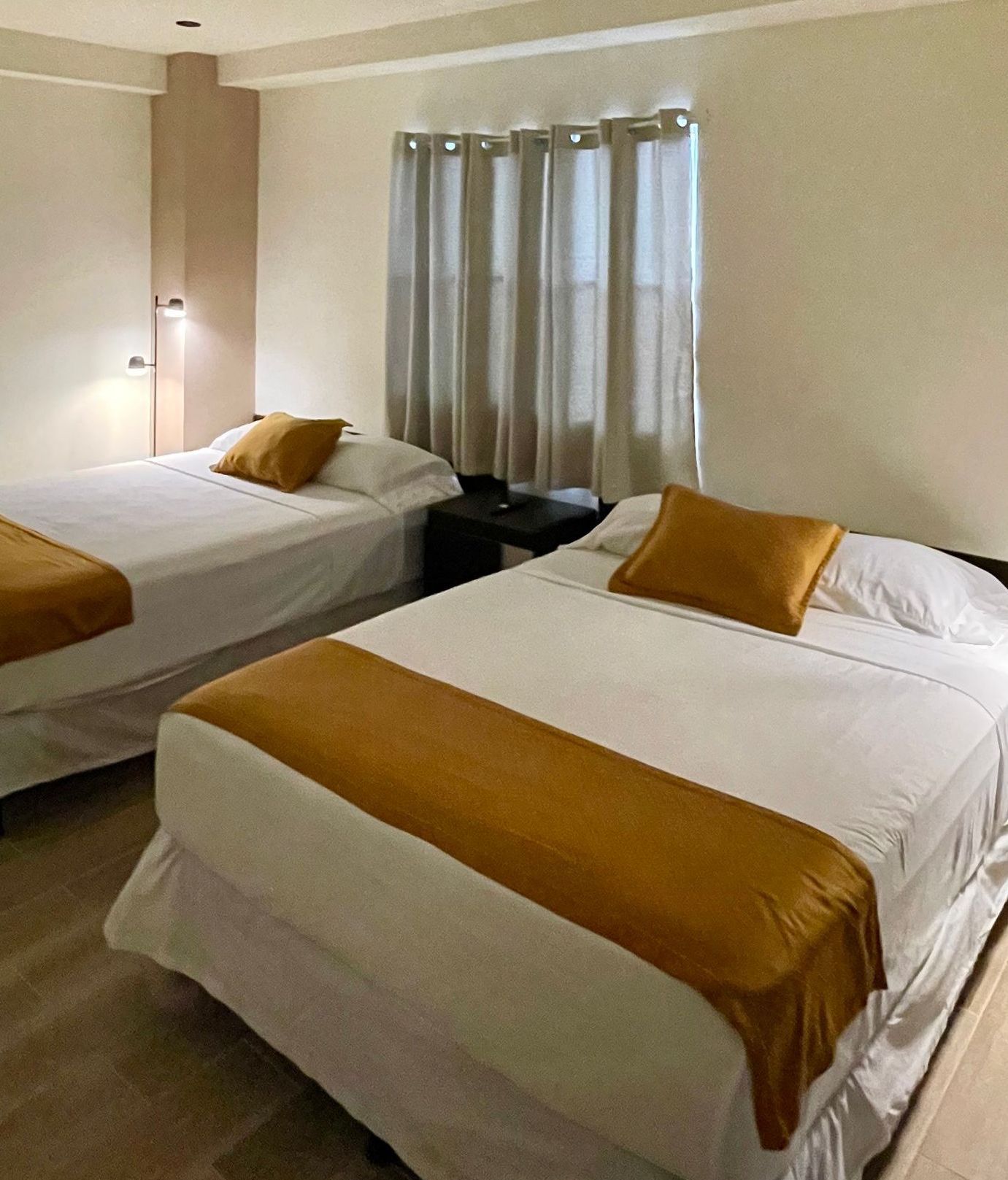 A hotel room with two beds and a window