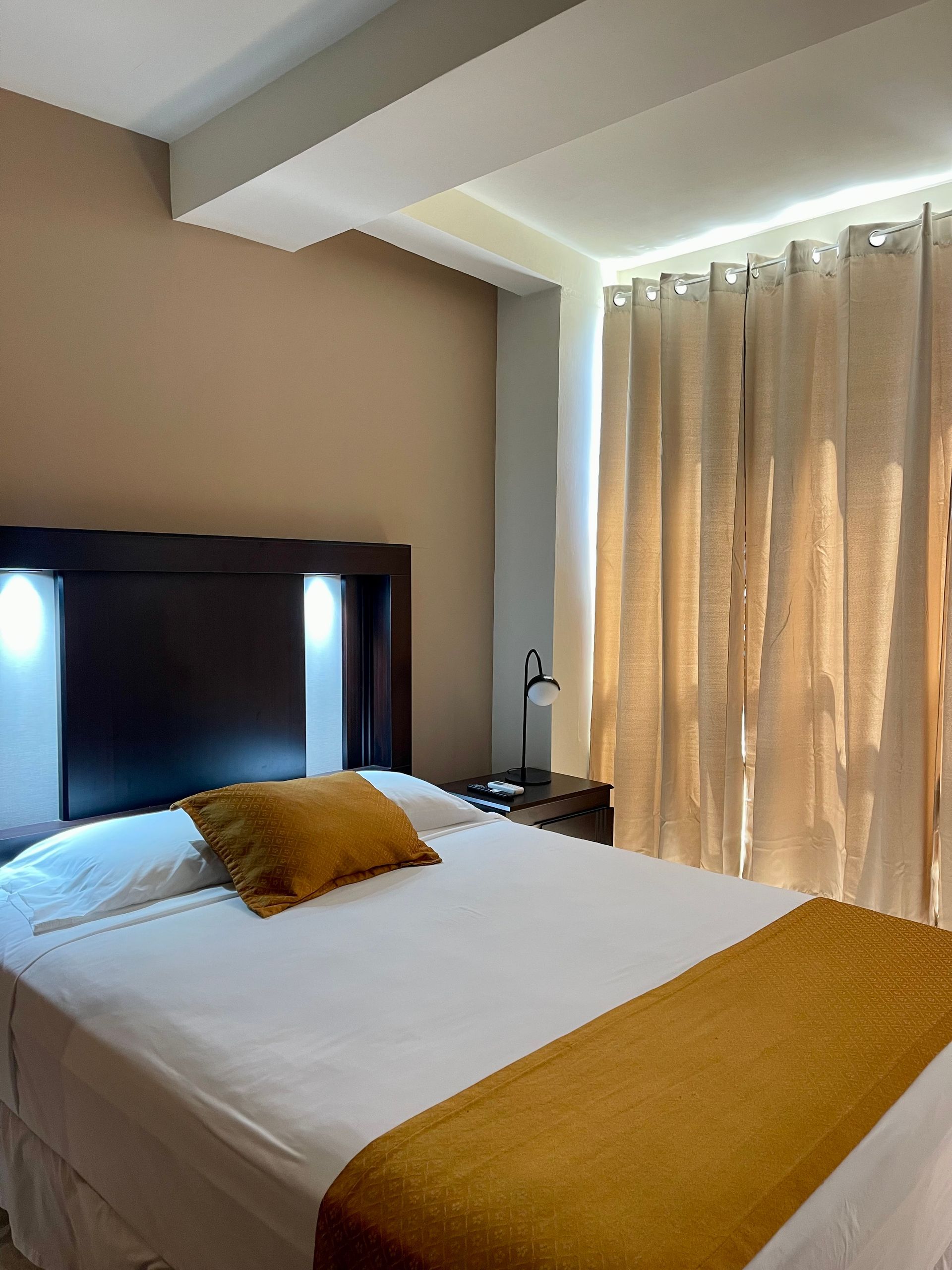 A hotel room with a bed and a window