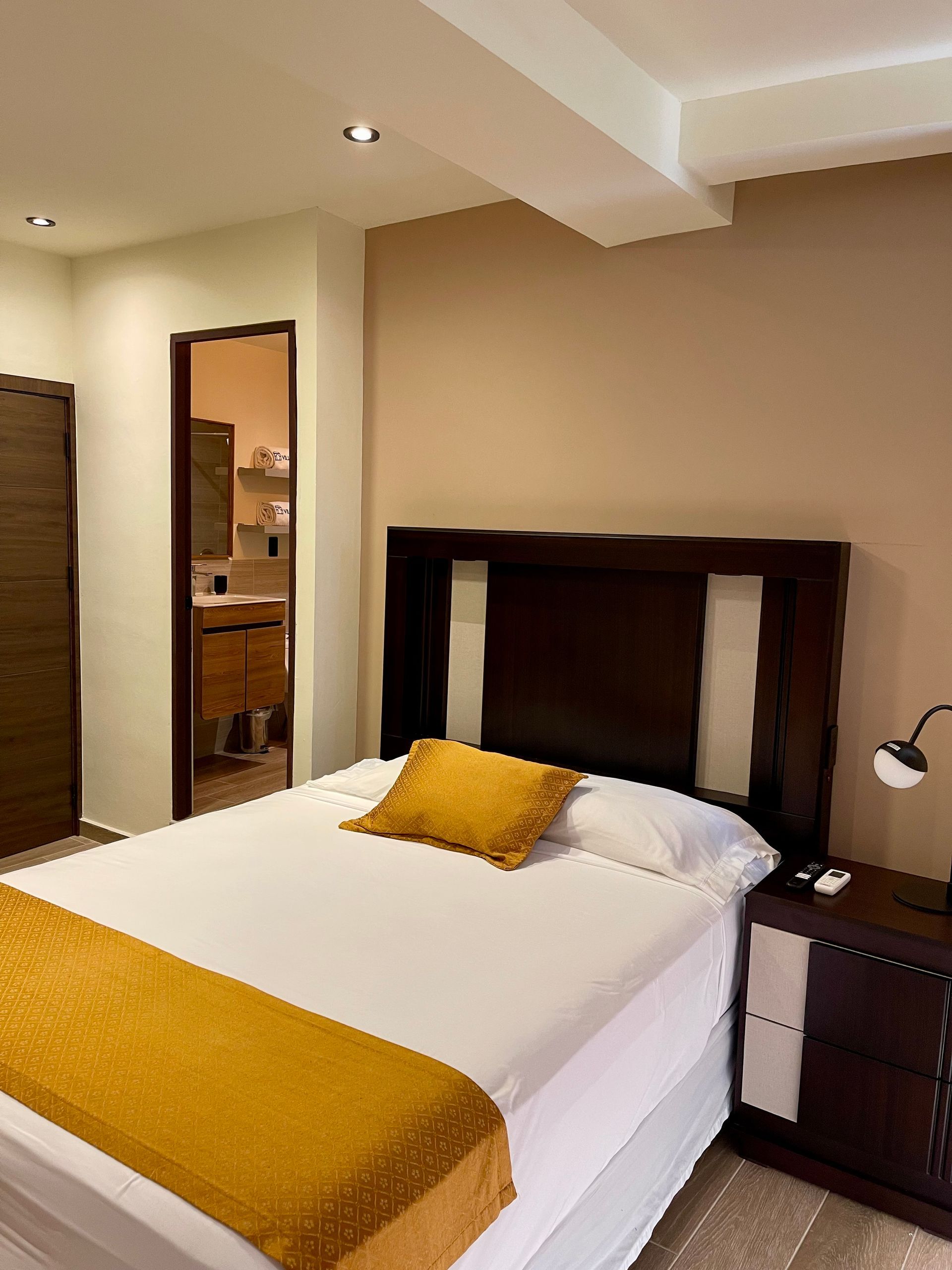 A bedroom with a large bed and a nightstand