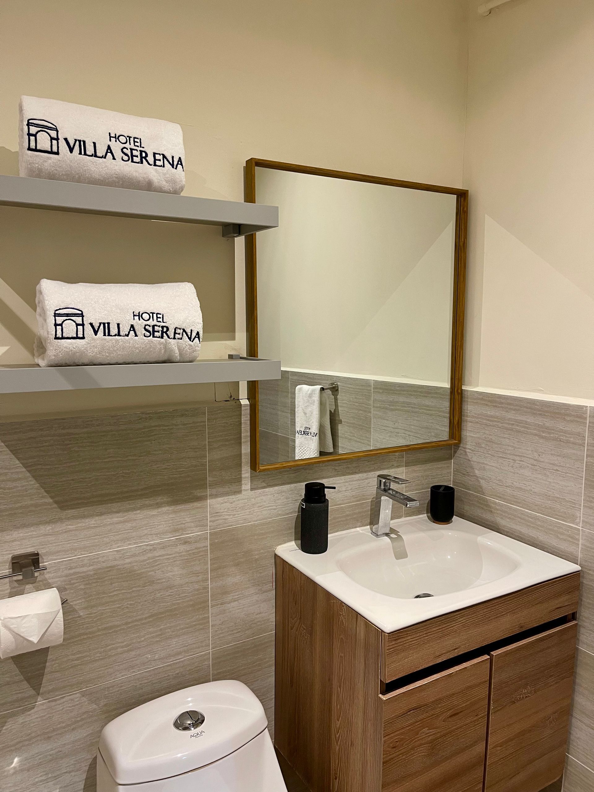 A bathroom with a sink , toilet and mirror.