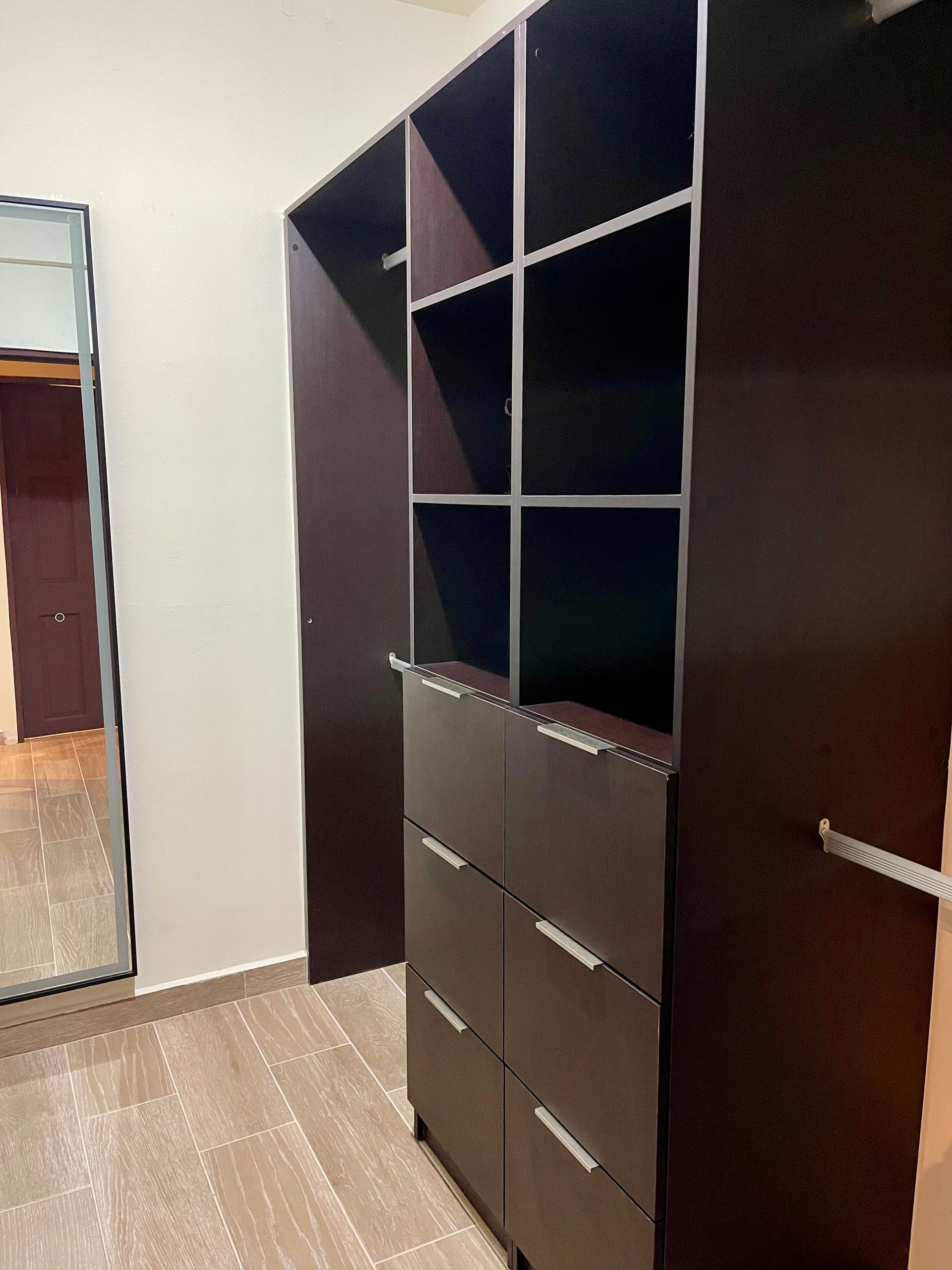 A walk in closet with lots of shelves and drawers