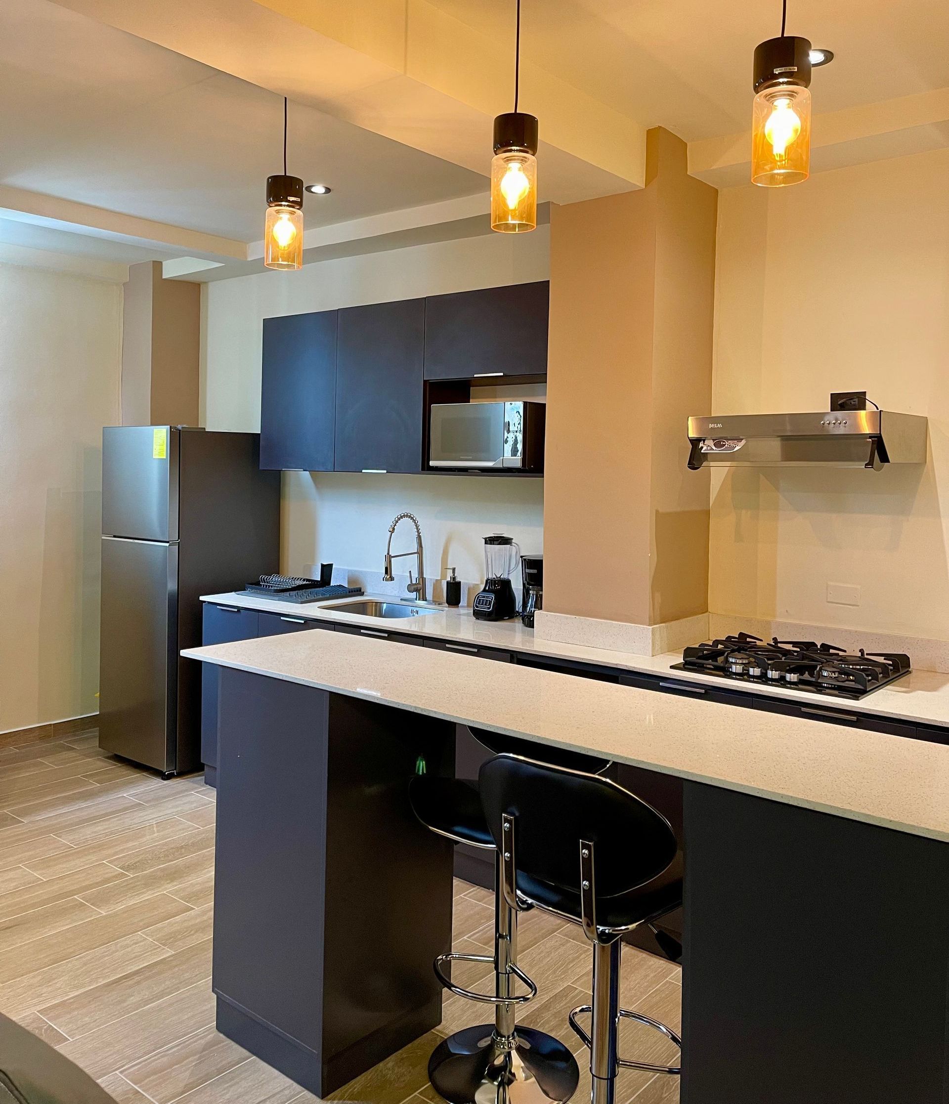 A kitchen with a stove top oven and a refrigerator