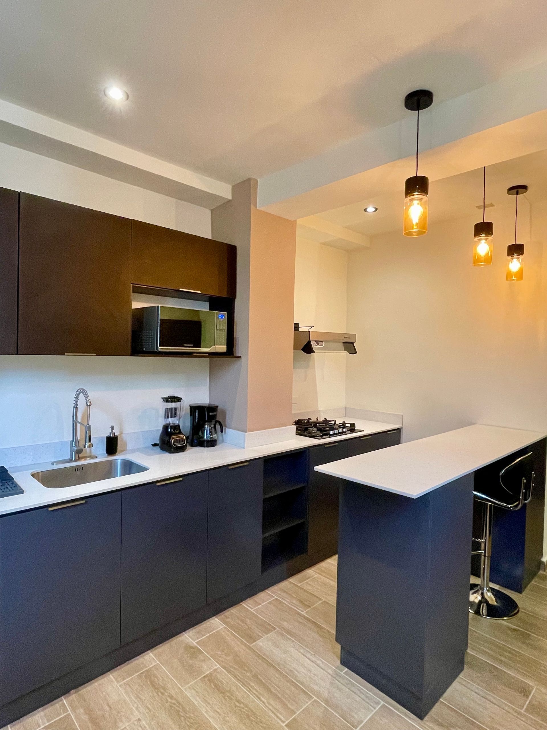 A kitchen with a sink , stove and microwave