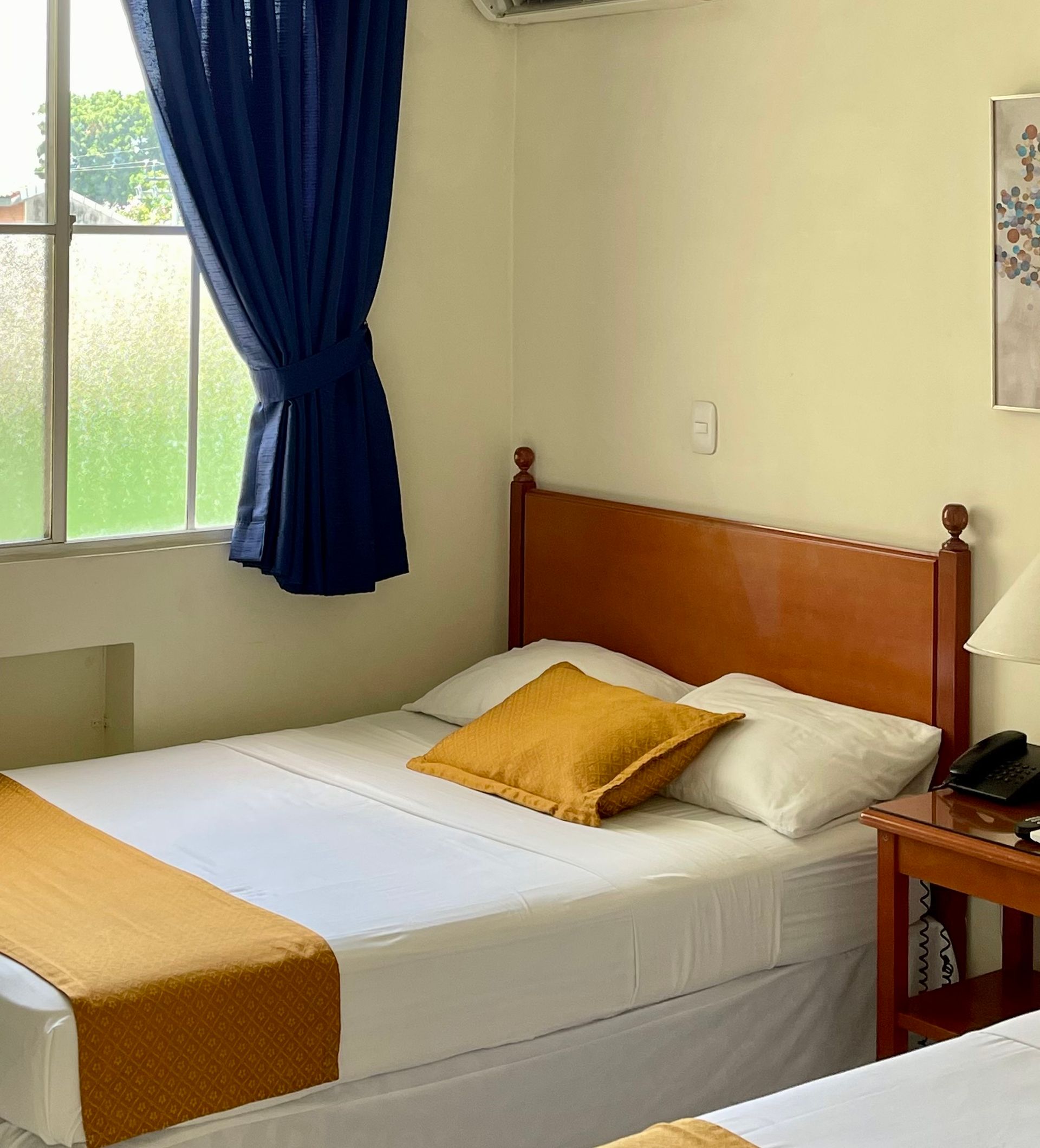 A hotel room with two beds and a window