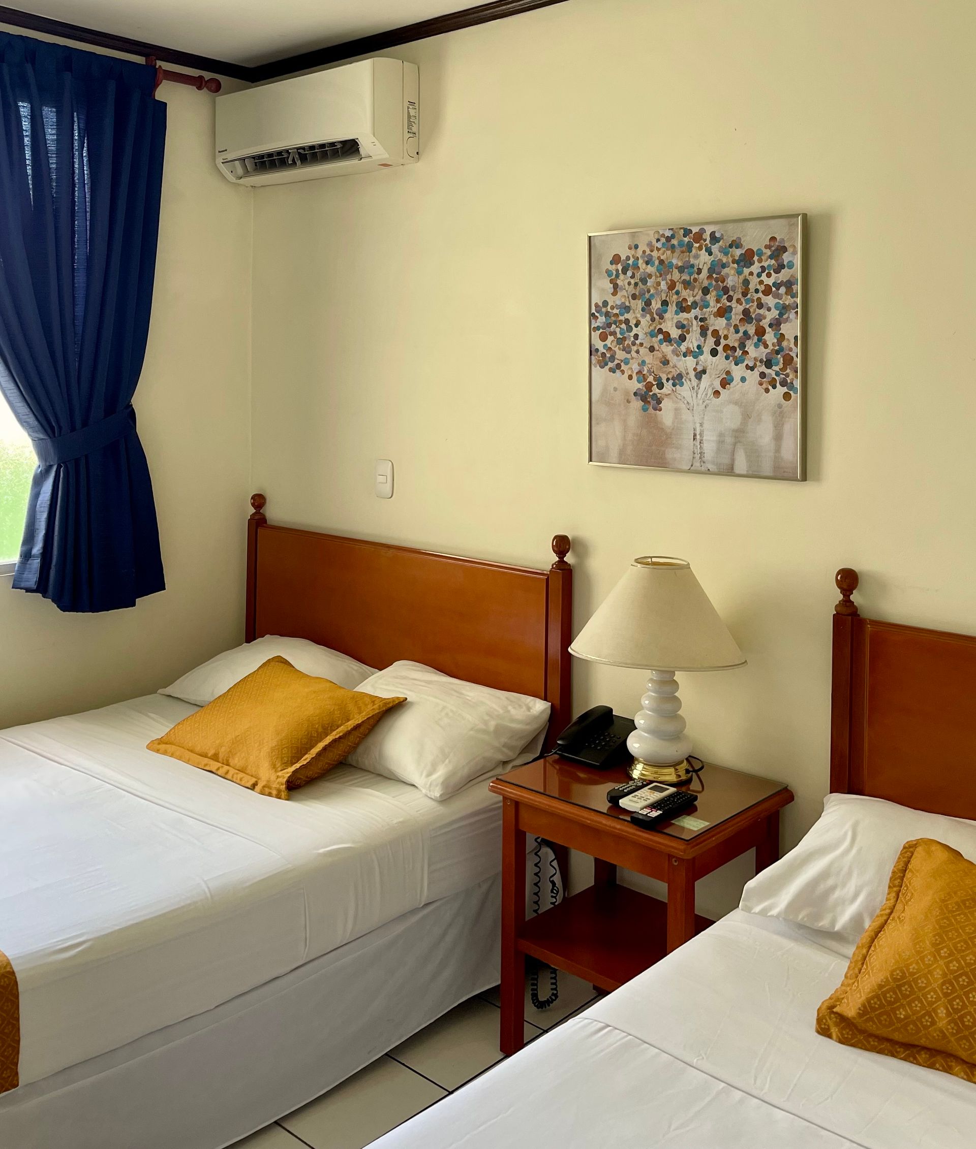 A hotel room with two beds and a lamp