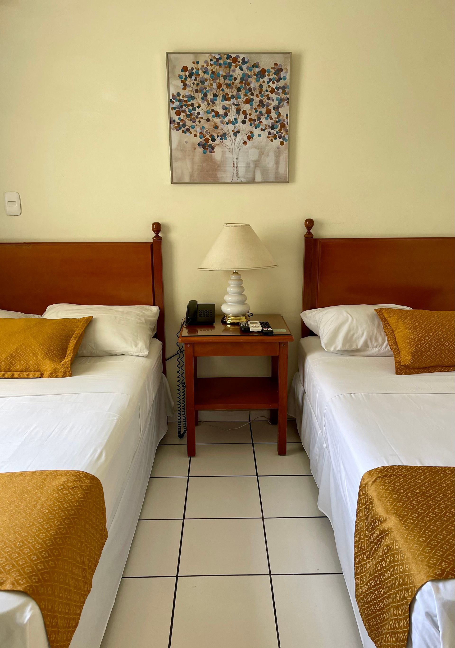 A hotel room with two beds and a lamp