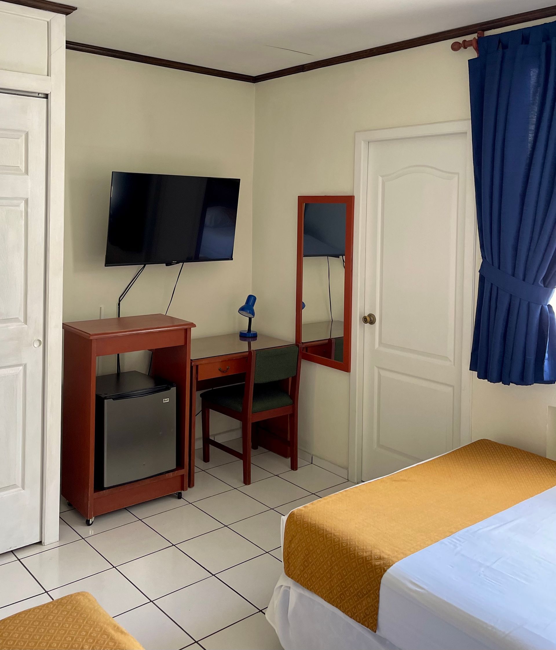 A hotel room with two beds and a flat screen tv