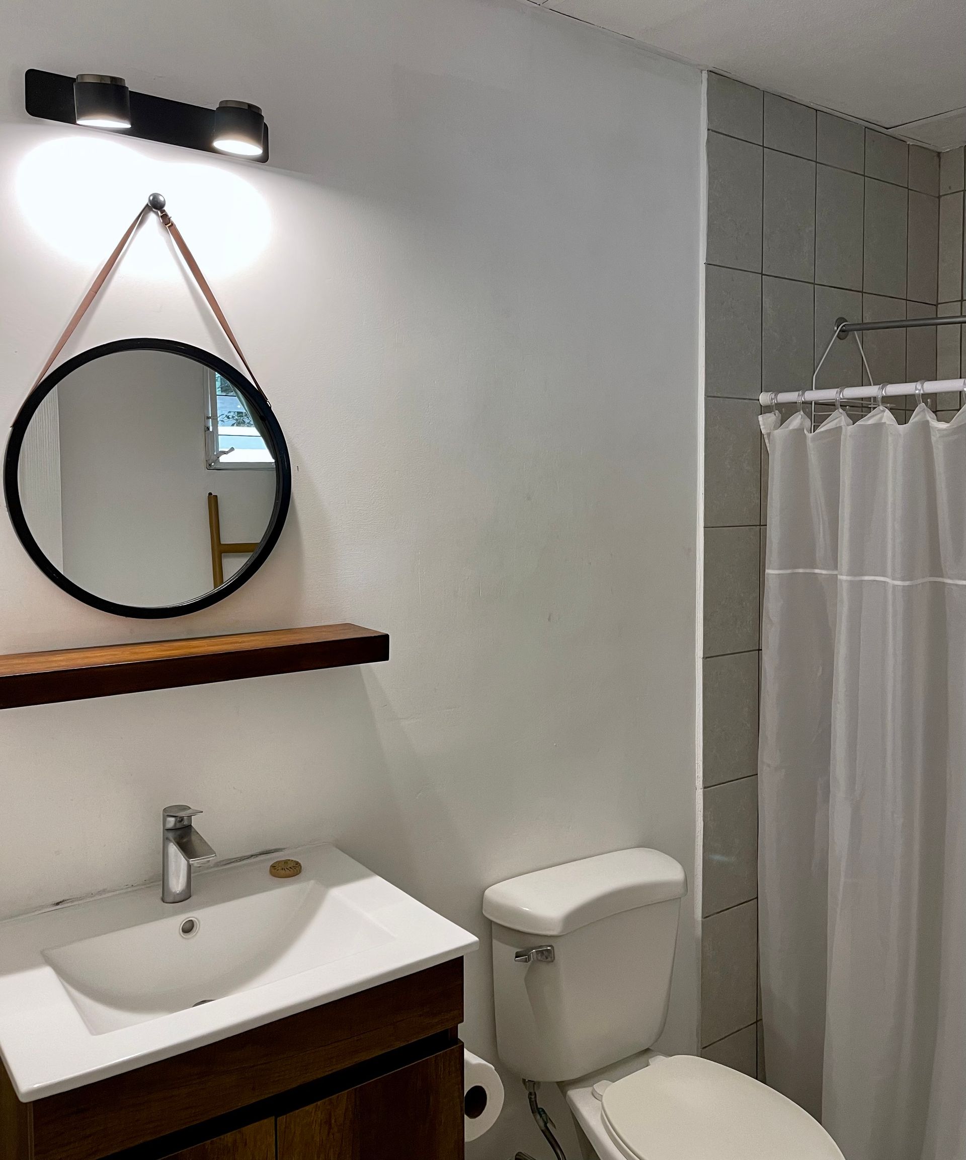 A bathroom with a toilet a sink and a mirror