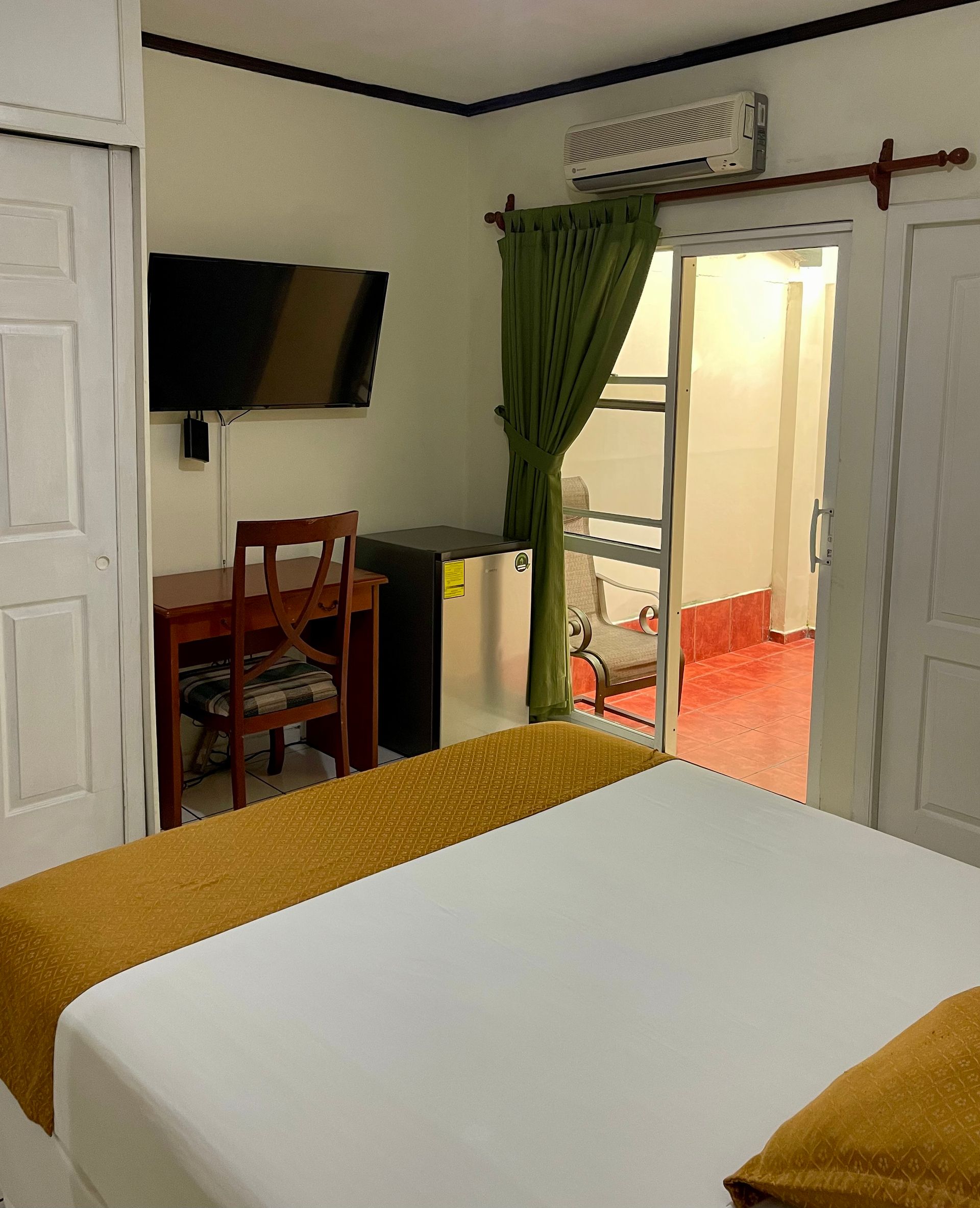 A hotel room with a bed a desk and a television