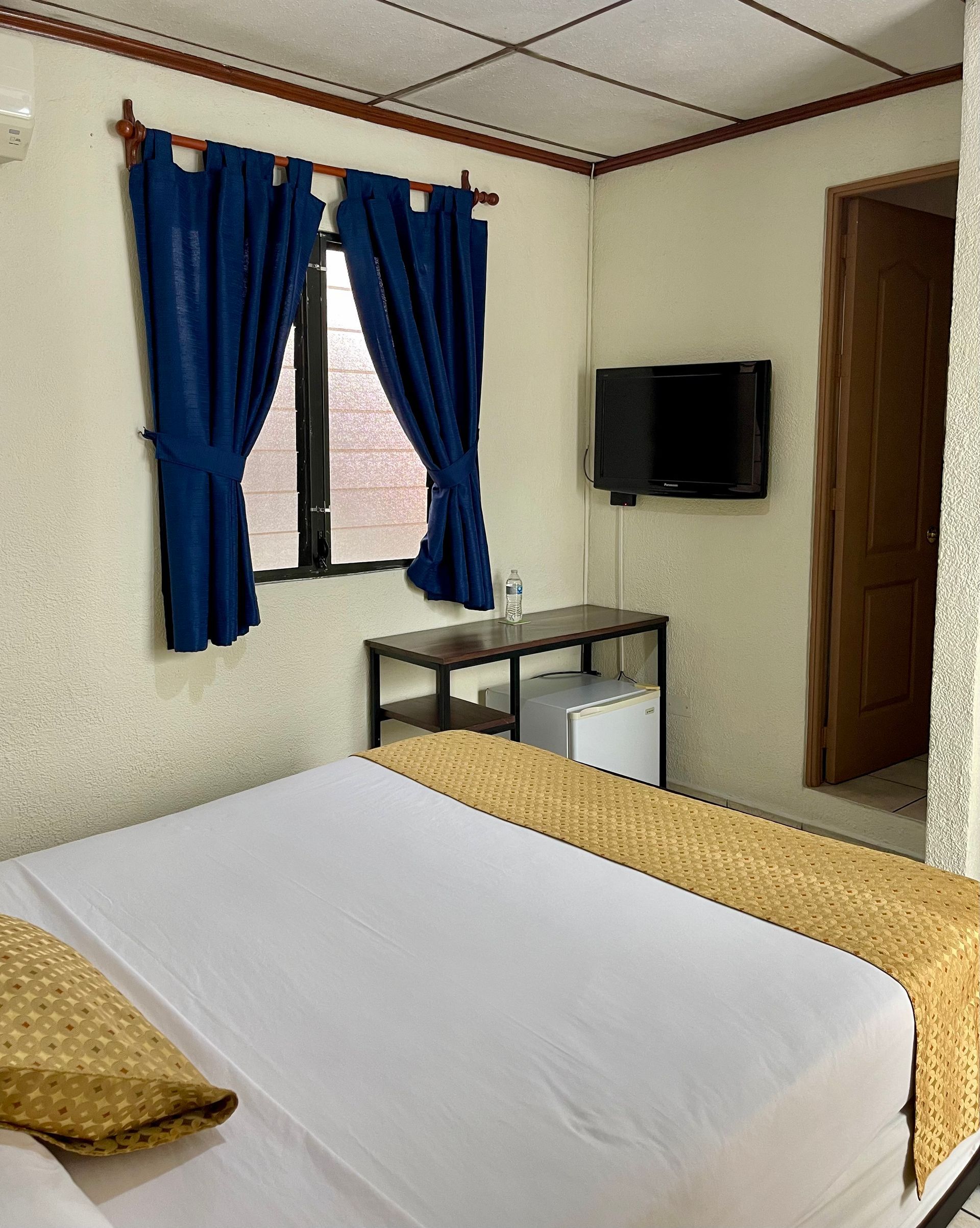 A hotel room with a bed and a television