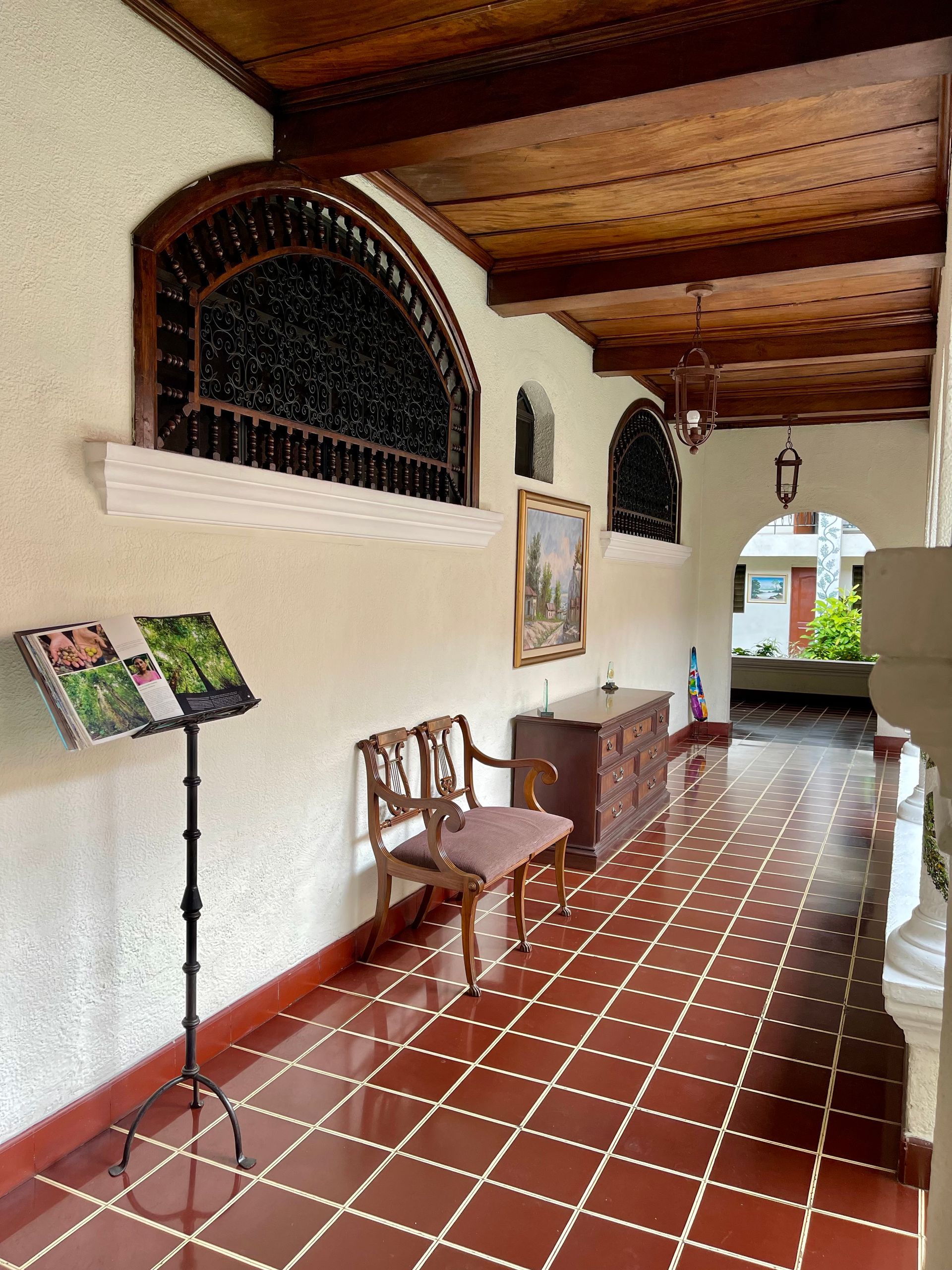 A hallway with a chair and a book on a stand