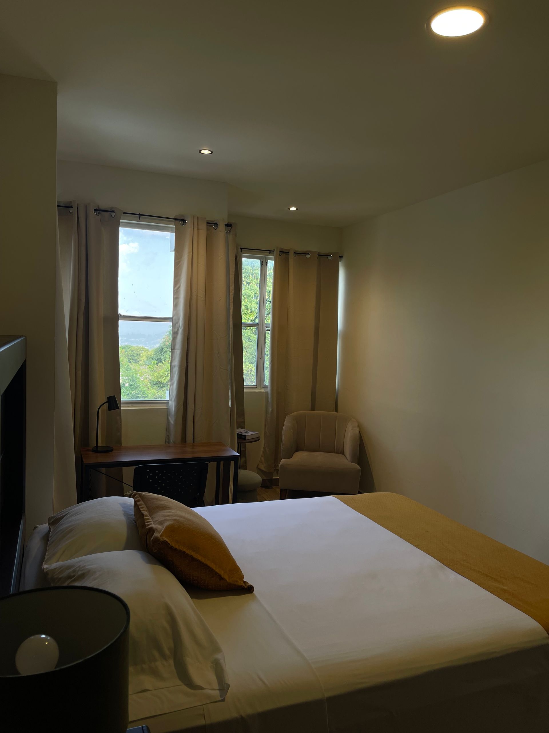 A bedroom with a bed a chair and a window