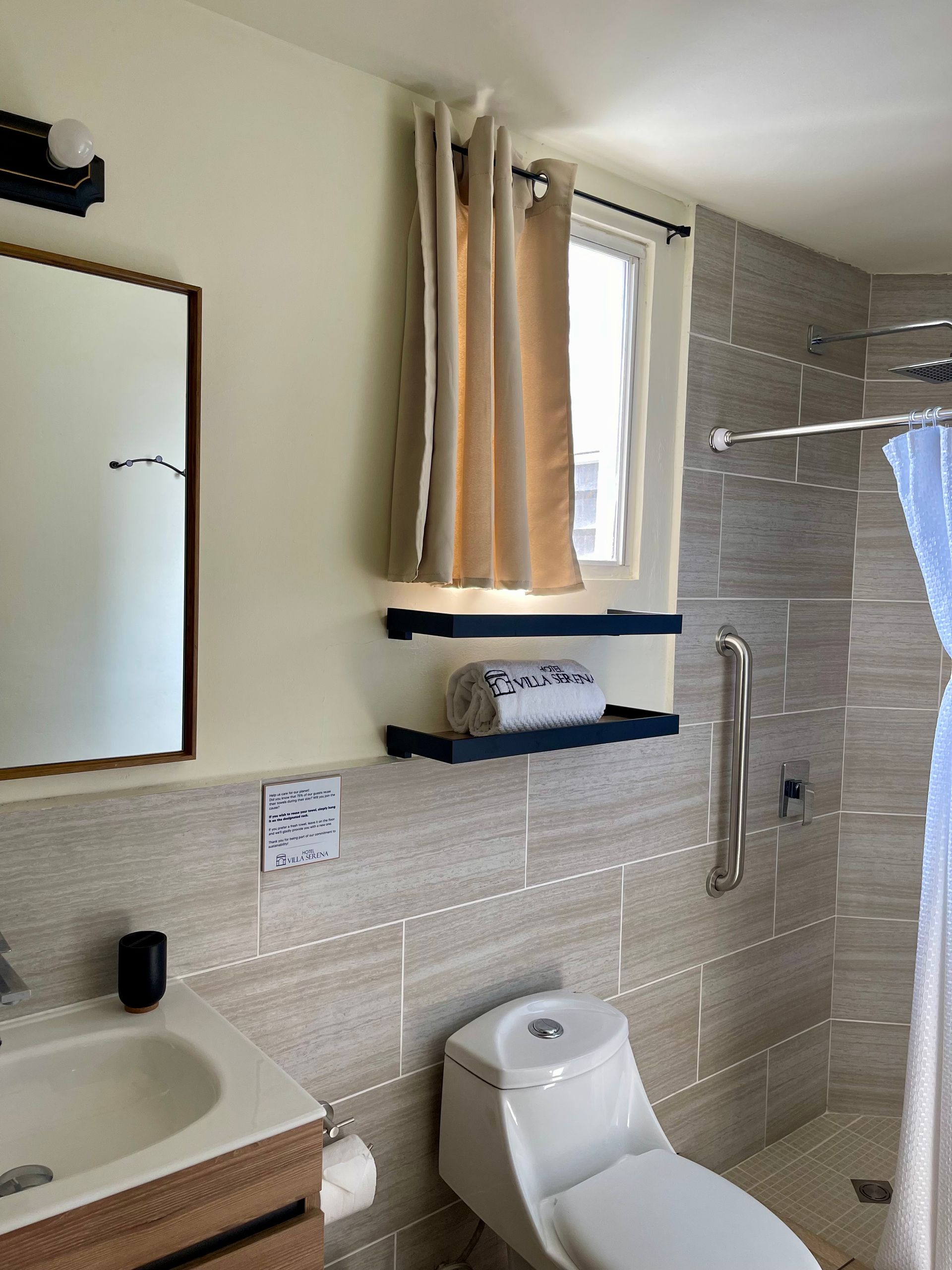 A bathroom with a toilet a sink and a window