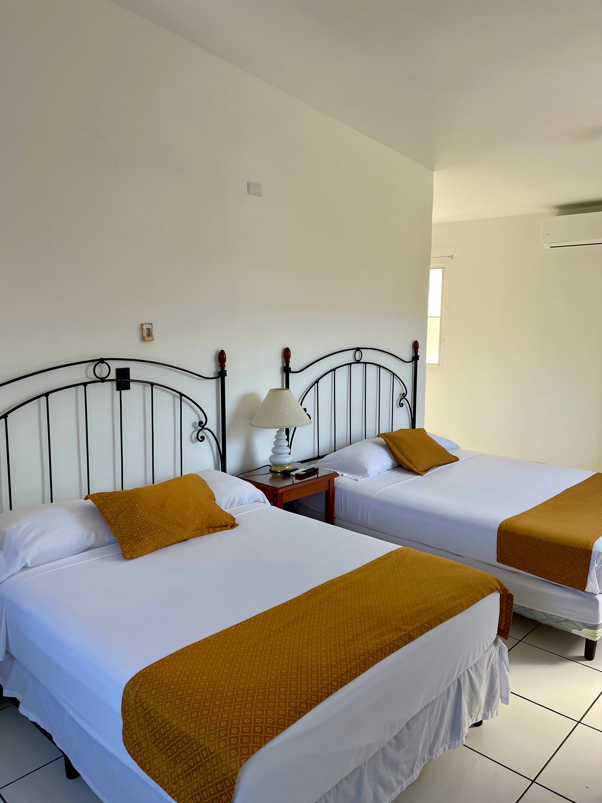 A hotel room with two beds and a lamp