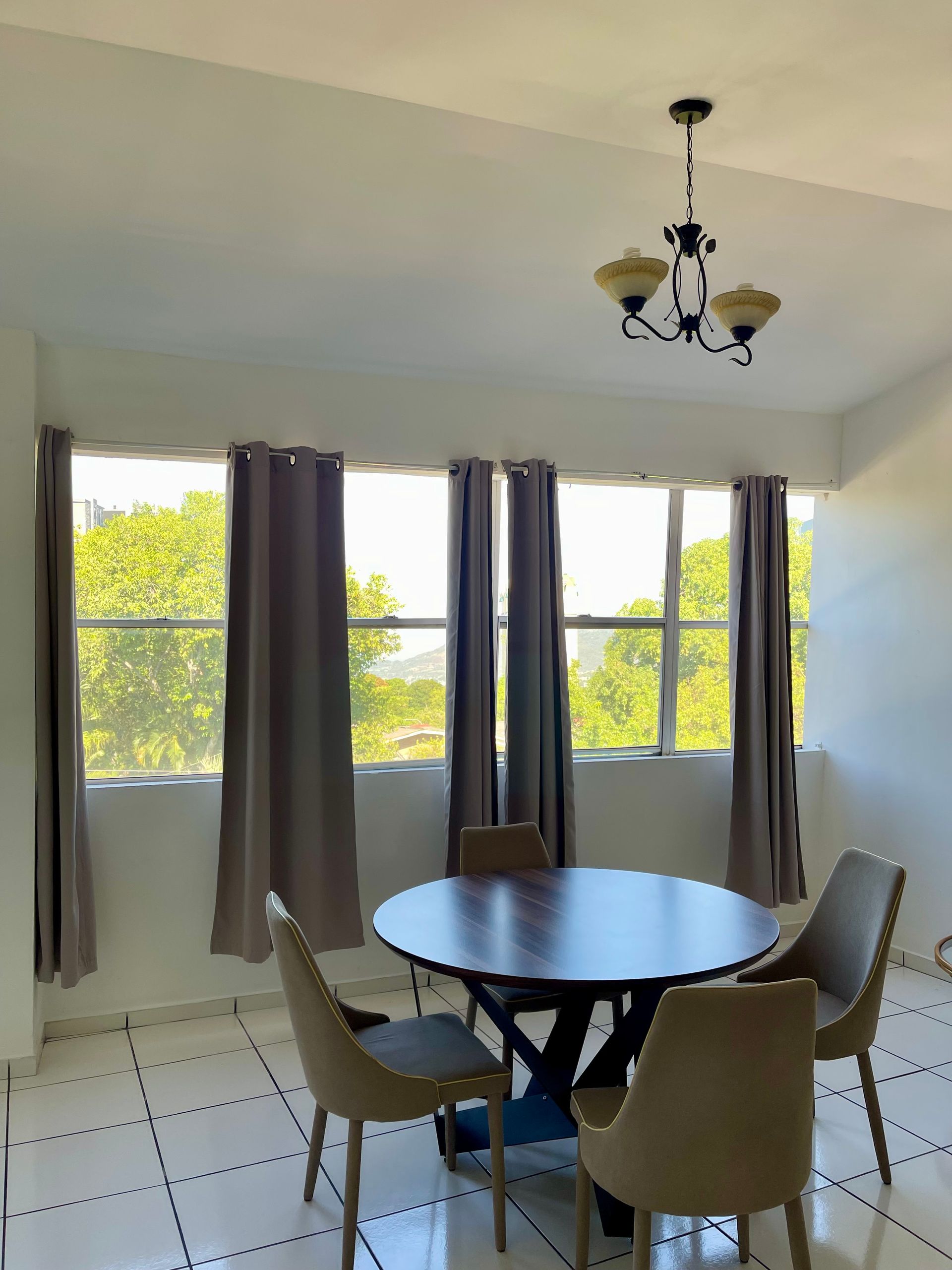 A dining room with a table and chairs and a chandelier