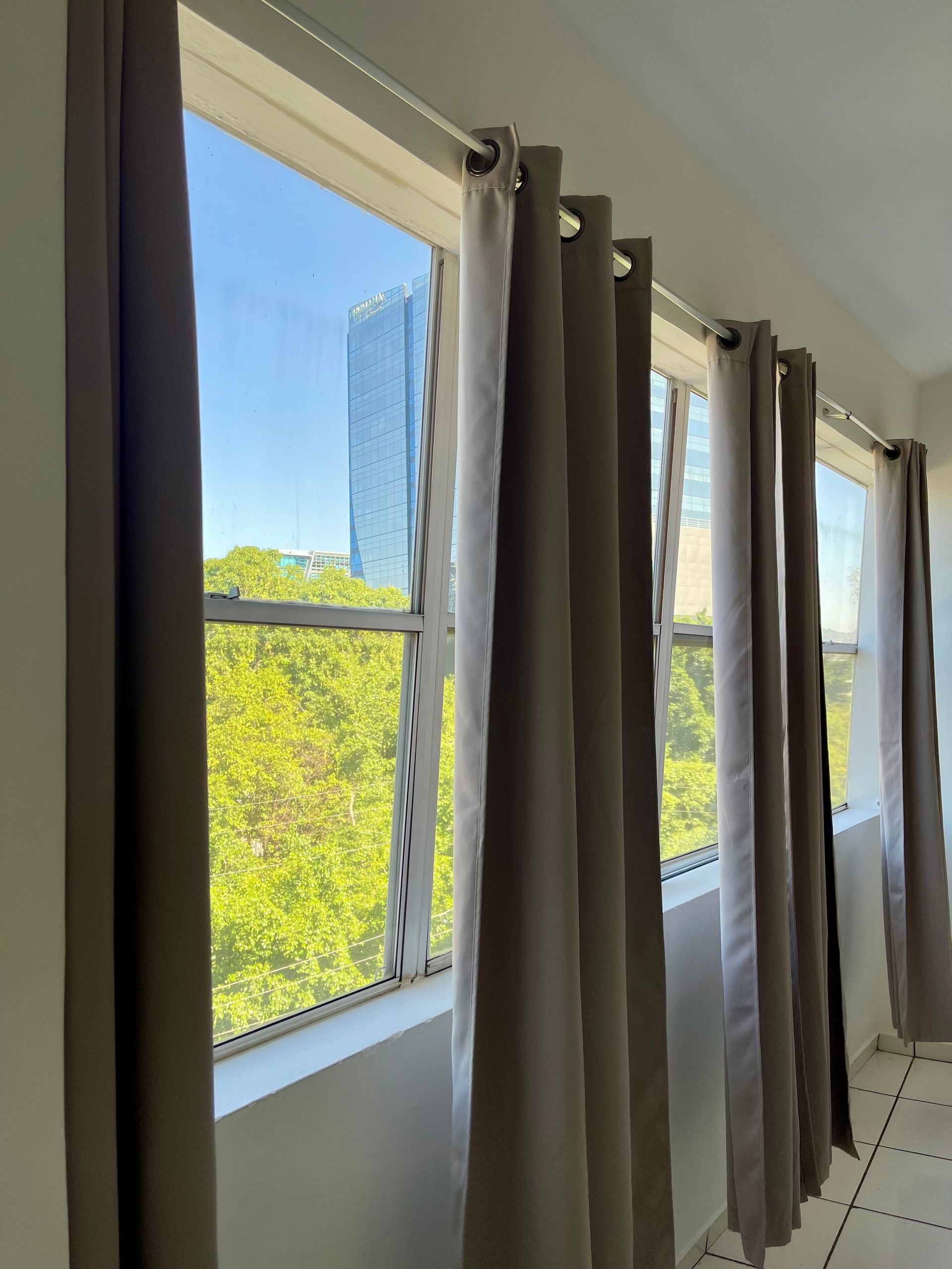 A row of curtains are hanging on a window in a room