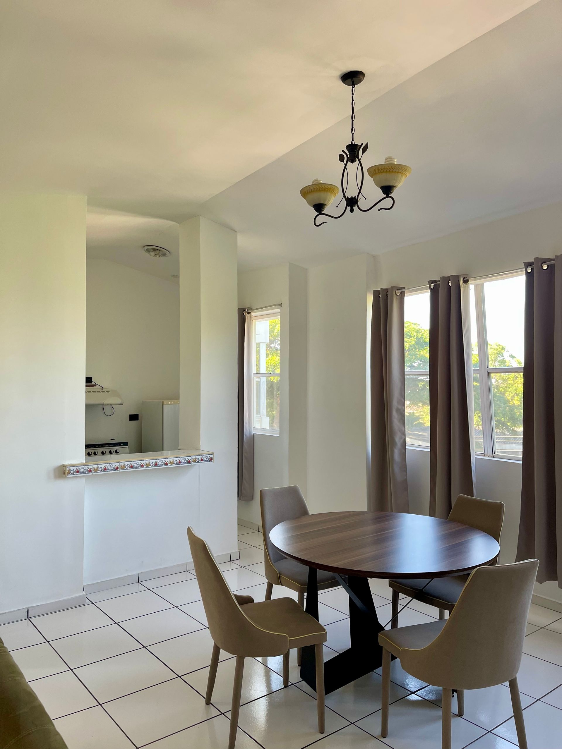 A dining room with a table and chairs and a chandelier hanging from the ceiling
