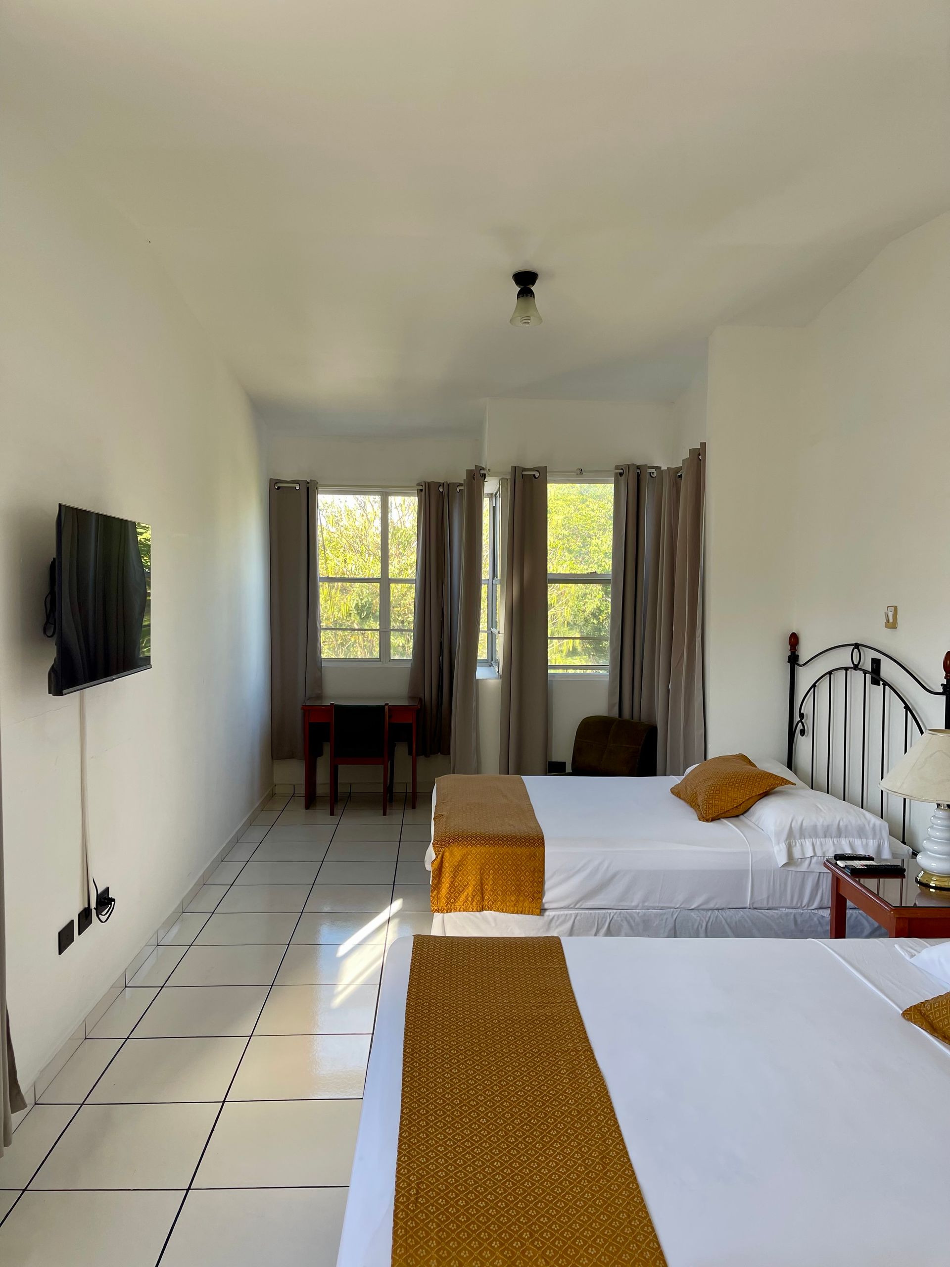 A hotel room with two beds and a flat screen tv