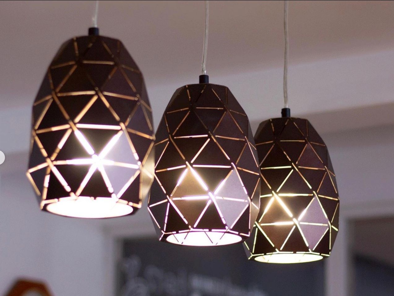 Three pendant lights are hanging from the ceiling in a room